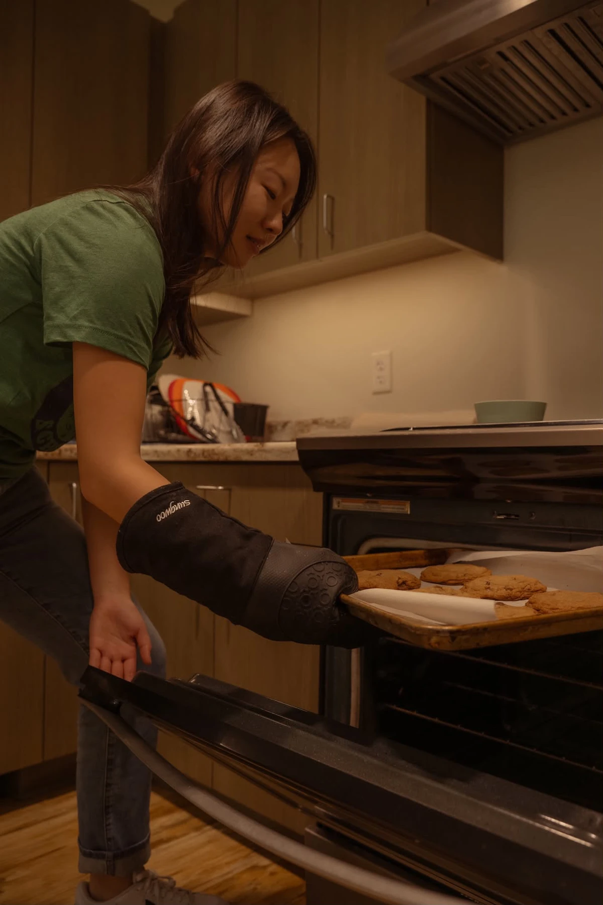 A Bright Bites volunteer taking a tray of cookies out of the oven
