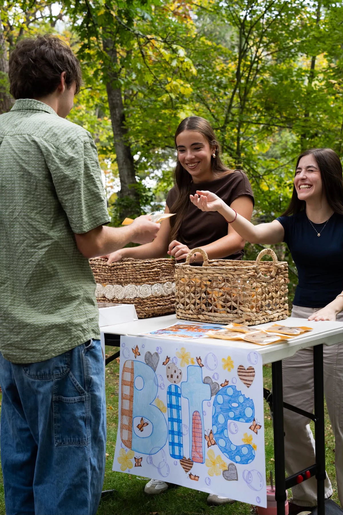 Bright Bites volunteers speaking with a customer at the fundraising table